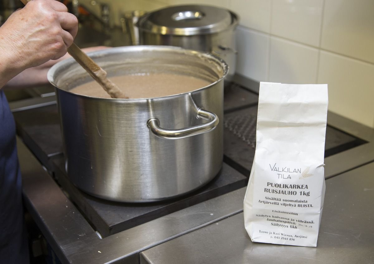 A large pot being stirred on a stove, a bag of flour beside it.